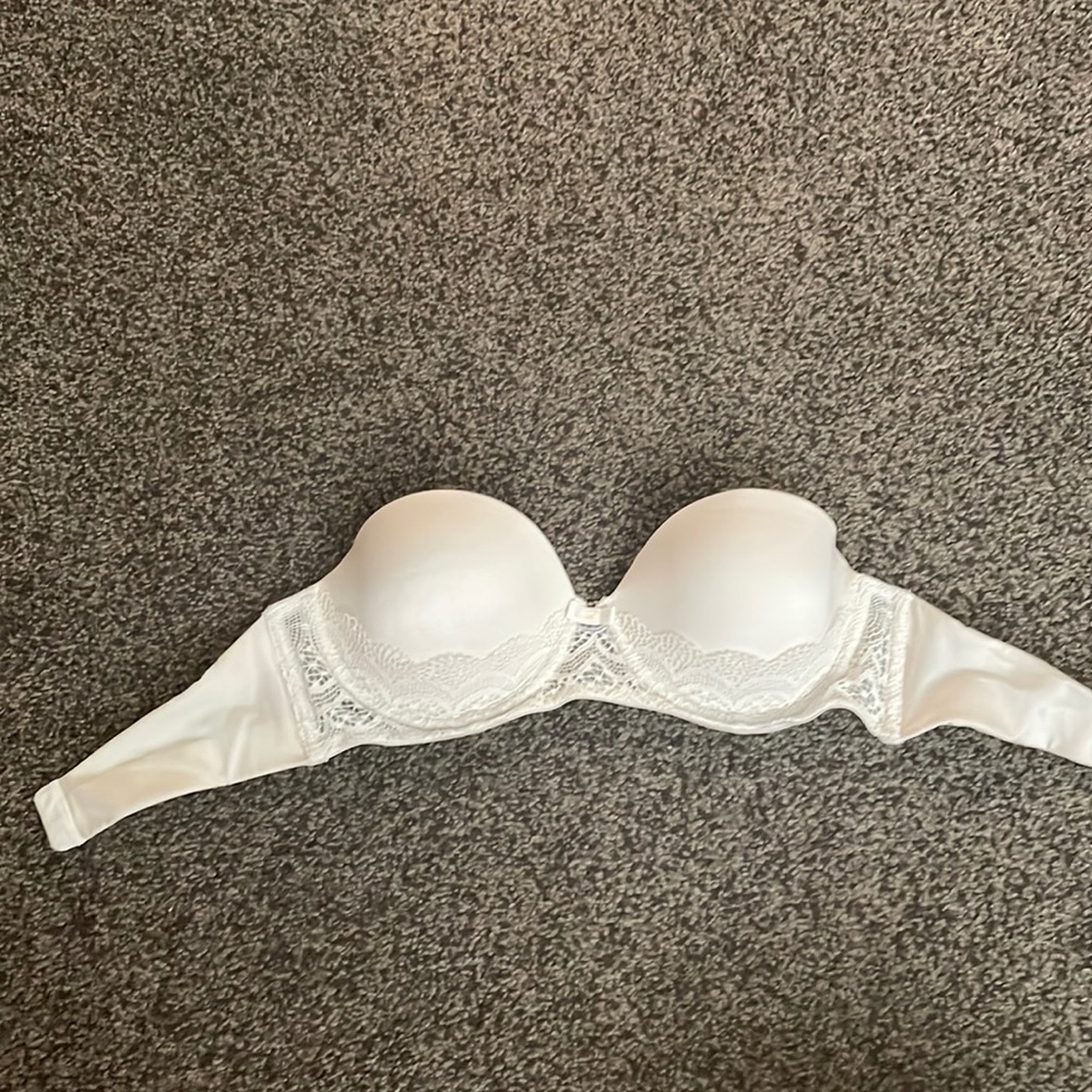 White strapless bra with lace detailing. It’s in good condition.